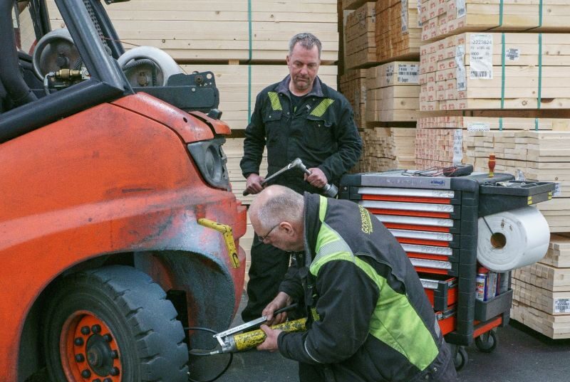 Twee medewerkers van de technische dienst van Gooskens Hout met een gereedschapskist tijdens onderhoud aan een heftruck.